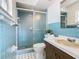Bathroom features a shower with sliding glass door and blue square wall tiles at 601 Francis St, Kissimmee, FL 34741