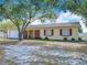 Welcoming single-story home with a classic design, mature tree, and red window shutters at 601 Francis St, Kissimmee, FL 34741