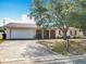 Single-story home features attached garage, mature landscaping, and inviting curb appeal at 601 Francis St, Kissimmee, FL 34741