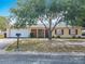 Charming one-story home with a mature tree, attached garage, and well-maintained front yard at 601 Francis St, Kissimmee, FL 34741