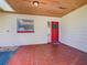 Inviting front porch showcasing a red door with a wreath, tiled flooring, and natural light from above at 601 Francis St, Kissimmee, FL 34741