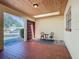 Enclosed front porch with tile flooring, wood ceiling, and outdoor seating area at 601 Francis St, Kissimmee, FL 34741