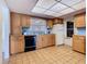 Traditional kitchen with wooden cabinetry, tile flooring, and a white refrigerator, offering a functional cooking space at 601 Francis St, Kissimmee, FL 34741