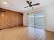 Cozy living room enhanced by a wood-paneled wall, ceiling fan, and sliding glass doors to an outdoor patio at 601 Francis St, Kissimmee, FL 34741