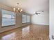 Open living room with tiled floors, abundant natural light from large windows, and chandelier at 601 Francis St, Kissimmee, FL 34741