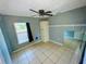 This bedroom includes a ceiling fan, window with blinds, and tiled flooring at 606 E Central Ave, Eagle Lake, FL 33839