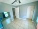 This bedroom includes a ceiling fan, window with blinds, and tiled flooring at 606 E Central Ave, Eagle Lake, FL 33839