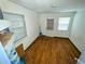 Empty room featuring wood floors, two windows, and white walls at 606 E Central Ave, Eagle Lake, FL 33839