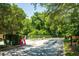 View of the community entrance gate, framed by lush greenery and mature trees at 617 Red Oak Cir # 121, Altamonte Springs, FL 32701
