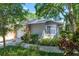 View of home featuring brick accents, two-car garage, a window, and lush landscaping at 617 Red Oak Cir # 121, Altamonte Springs, FL 32701