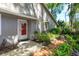 Home exterior with brick walkway leading to a red glass front door and lush, mature landscaping at 617 Red Oak Cir # 121, Altamonte Springs, FL 32701