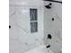 Bathroom boasts a bathtub and shower featuring marble-look walls, black matte hardware, and a niche for toiletries at 6216 Beaumont Ave, Orlando, FL 32808