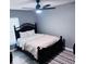 Well-lit bedroom features a dark wood frame bed, ceiling fan, and an area rug on light colored floors at 6216 Beaumont Ave, Orlando, FL 32808