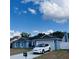 Charming one-story home with manicured lawn, blue paint, and a white electric car charging in the driveway at 6216 Beaumont Ave, Orlando, FL 32808