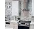 Close-up of the modern kitchen featuring white cabinets, stainless steel appliances, and decorative backsplash at 6216 Beaumont Ave, Orlando, FL 32808