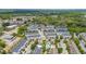 Wide aerial shot of the neighborhood featuring townhomes, mature trees, and community pool at 704 Grado Pt, Oviedo, FL 32765