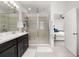 Bathroom featuring a double sink vanity, a glass-enclosed shower, and an open doorway to the bedroom at 704 Grado Pt, Oviedo, FL 32765