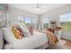Bright bedroom with a decorative accent wall, desk, and three windows showcasing natural light at 704 Grado Pt, Oviedo, FL 32765