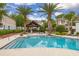 Community pool featuring palm trees, lounge chairs and a covered patio at 704 Grado Pt, Oviedo, FL 32765