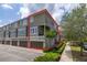 Exterior view of a multi-story townhouse with a two-car garage and a well-manicured lawn, and large windows at 704 Grado Pt, Oviedo, FL 32765