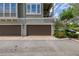 Townhouse garage, featuring paneled doors and a paver stone driveway, with lush landscaping at 704 Grado Pt, Oviedo, FL 32765