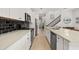 Open kitchen with stainless steel appliances, white cabinets, breakfast bar, stone countertops, and easy access to stairs at 704 Grado Pt, Oviedo, FL 32765