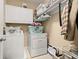 Efficient laundry room with washer, dryer, storage cabinets, and shelving at 704 Grado Pt, Oviedo, FL 32765