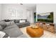 Inviting living room with a gray sectional, leather ottoman, and entertainment center at 704 Grado Pt, Oviedo, FL 32765