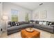 Comfortable living room featuring a large gray sectional and stylish leather ottoman at 704 Grado Pt, Oviedo, FL 32765