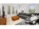 Comfortable living room showcasing a gray sectional, a leather ottoman, and ample natural light at 704 Grado Pt, Oviedo, FL 32765