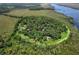 Picturesque aerial view of a secluded property surrounded by lush greenery and a winding river at 7374 Circle Dr, Lady Lake, FL 32159