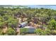 Aerial view of the property showcasing the house, outbuildings, and surrounding trees at 7374 Circle Dr, Lady Lake, FL 32159