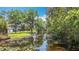 Picturesque view of a pond in the backyard, enhanced by lush trees and a glimpse of the house at 7374 Circle Dr, Lady Lake, FL 32159