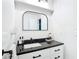 Contemporary bathroom vanity with black countertop and arched mirror at 7374 Circle Dr, Lady Lake, FL 32159