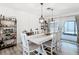 Bright dining room with modern chandelier lighting, white wood furniture, and large windows at 7374 Circle Dr, Lady Lake, FL 32159