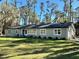 Charming single-story home with a well-maintained lawn and a backdrop of mature trees at 7374 Circle Dr, Lady Lake, FL 32159