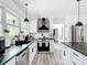 Contemporary kitchen with white cabinetry, marble countertops, and stainless-steel appliances, offering a stylish design at 7374 Circle Dr, Lady Lake, FL 32159