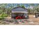 Metal outbuilding with attached awning and tractor, ideal for property maintenance and storage at 7374 Circle Dr, Lady Lake, FL 32159
