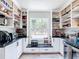 Well-organized pantry with black marble countertops, white cabinets, and a window to the backyard view at 7374 Circle Dr, Lady Lake, FL 32159