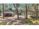 Exterior view of a home with a separate metal outbuilding situated in a wooded landscape at 7374 Circle Dr, Lady Lake, FL 32159