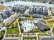 This aerial view showcases community amenities, including a pool, playground, tennis court and lake views for residents at 7565 Laureate Blvd # 3408, Orlando, FL 32827