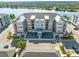 Beautiful aerial view of new condos by a lake with ample parking spaces and lush landscaping at 7565 Laureate Blvd # 3408, Orlando, FL 32827
