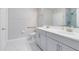 Bright bathroom featuring a double sink vanity, toilet, and walk-in shower with glass door at 7565 Laureate Blvd # 3408, Orlando, FL 32827