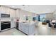 Open concept kitchen flows into a living room with a sliding glass door to a balcony and water views at 7565 Laureate Blvd # 3408, Orlando, FL 32827