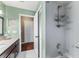 Well-lit bathroom with a shower caddy and a single sink with dark cabinets and a granite top at 819 E Harbour Ct, Ocoee, FL 34761