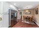 Bright dining area with hardwood floors, a modern chandelier, and stainless steel refrigerator at 819 E Harbour Ct, Ocoee, FL 34761