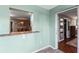 View through a pass-through into the dining room with modern light fixture and wood furniture at 819 E Harbour Ct, Ocoee, FL 34761