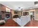 Cozy living room with brick fireplace, wood floors, and view into dining area at 819 E Harbour Ct, Ocoee, FL 34761