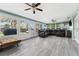 Bright sunroom with large windows, tile floors, and dark leather sofa at 819 E Harbour Ct, Ocoee, FL 34761