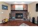 Cozy fireplace in living room with red brick surround and dark wood mantel at 819 E Harbour Ct, Ocoee, FL 34761